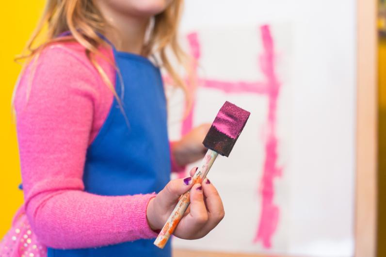 Enfant tenant un pinceau couvert de peinture