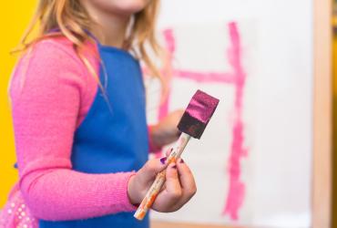 Enfant tenant un pinceau couvert de peinture